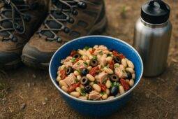 Bowl of Mediterranean tuna and white bean salad with herbs and olive oil, ready to serve outdoors.