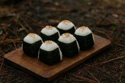 Golden-brown miso seaweed rice bars resting on a wooden board, ready to eat outdoors.